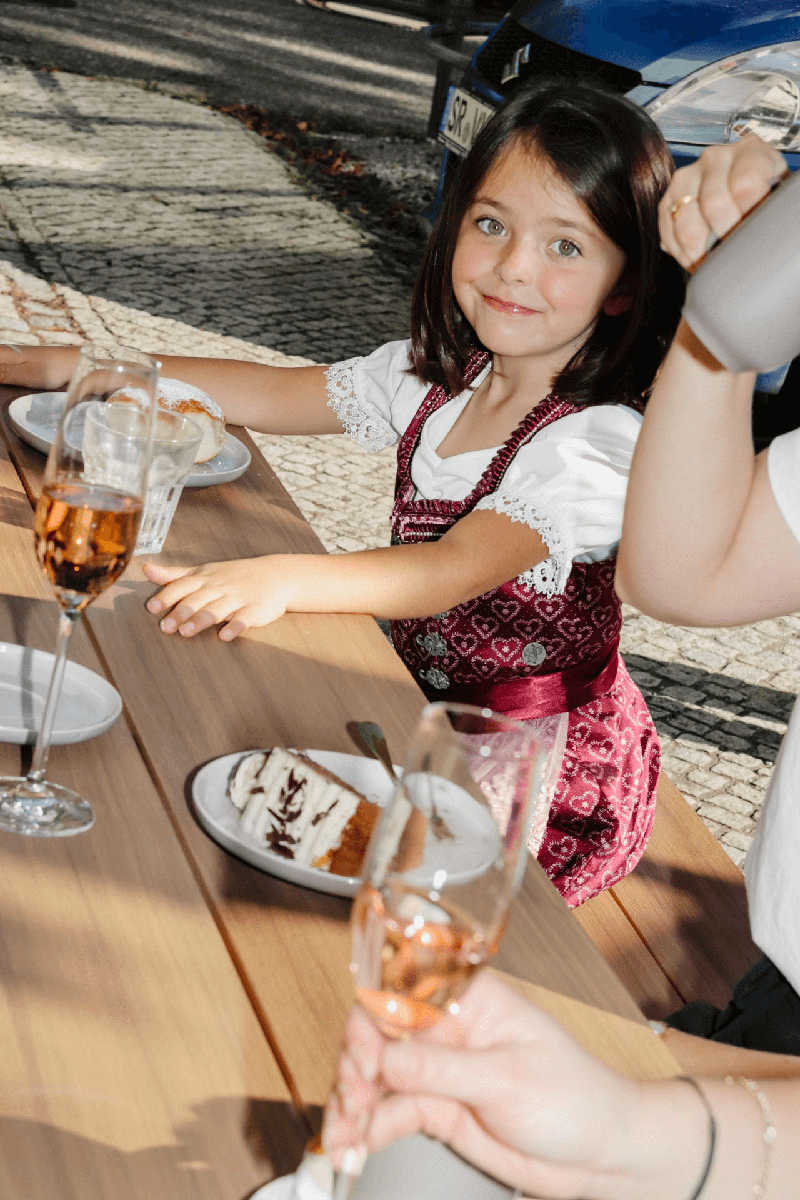 Kleines Mädchen isst Krapfen.